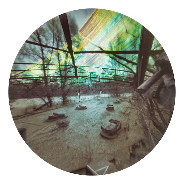 a circular image shows an abandoned amusement park with streaks of light above