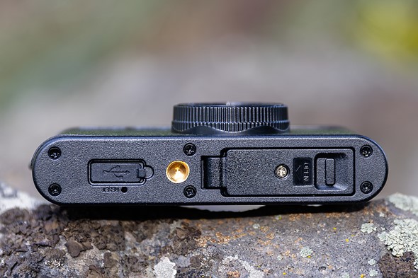 le bas de la caméra instantanée du camp montrant la prise de trépied du port USB et la porte de la carte mémoire