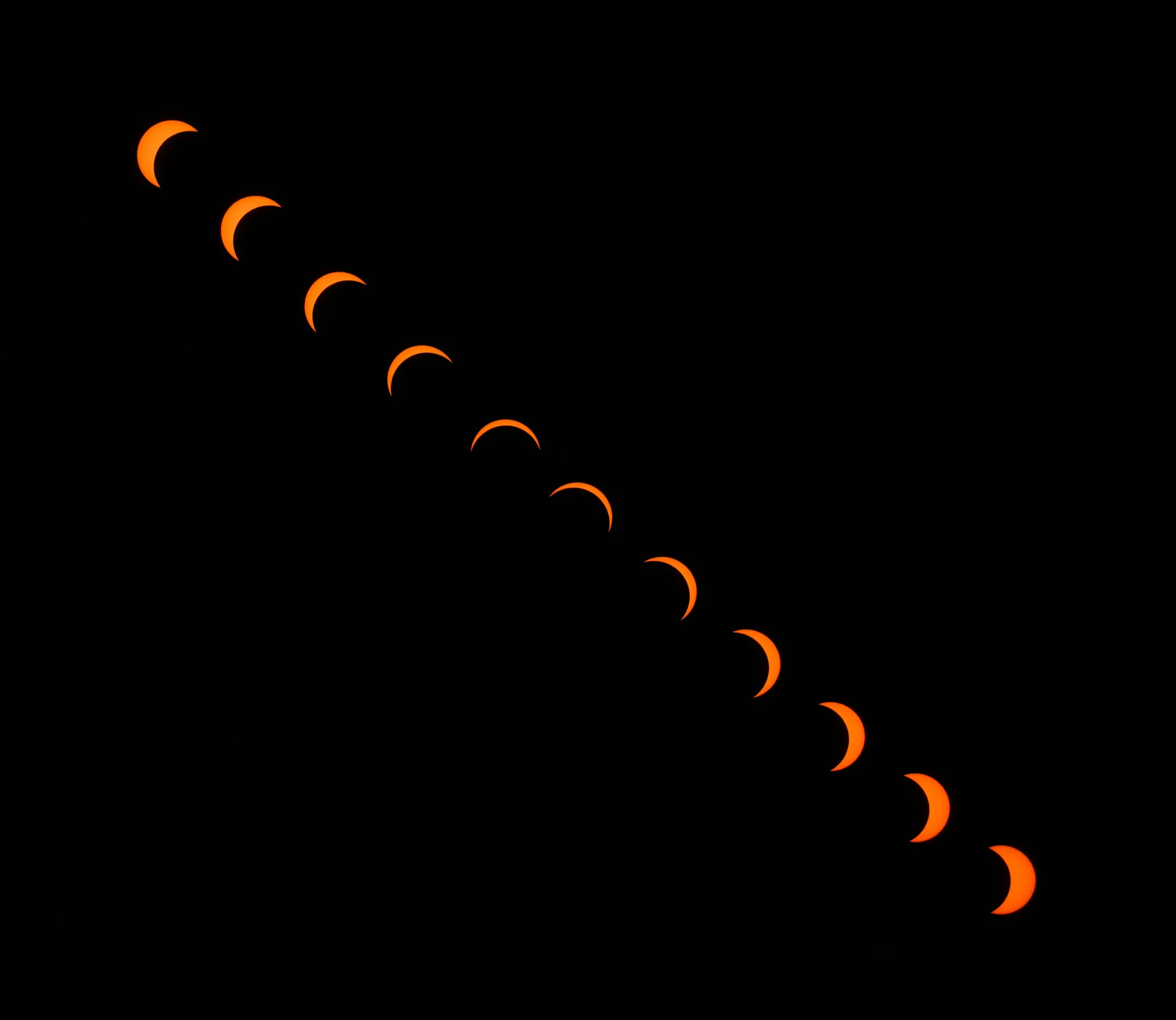 Timelapse composite of the August 12th eclipse, with the sun rendered as several orange slices.