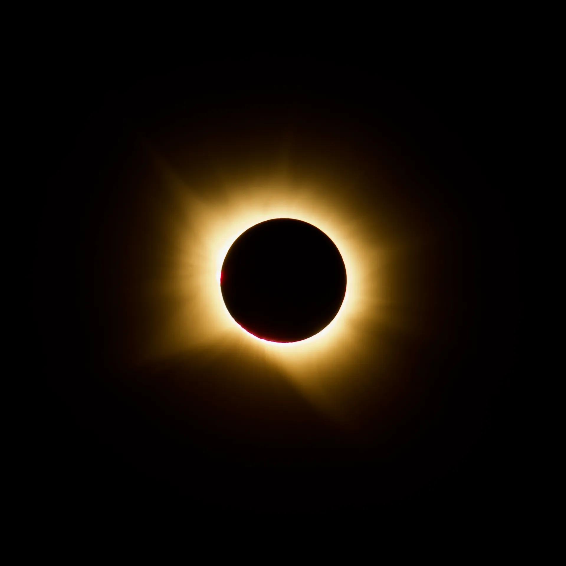 A photo of the eclipse, with a halo of yellow light around the silhouette of the moon.