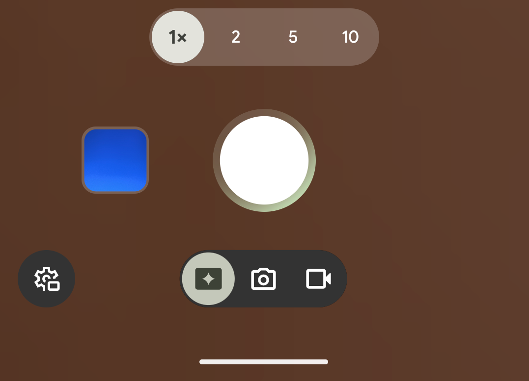 Smartphone camera app interface displaying zoom options (1x, 2, 5, 10), a prominent white shutter button in the center, video and camera mode icons, a blue square icon on the left side, and a settings gear icon located below.