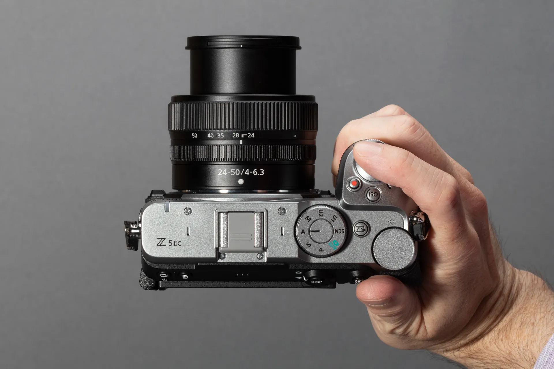 A top-down view of a hand holding a silver Nikon Z5IIC