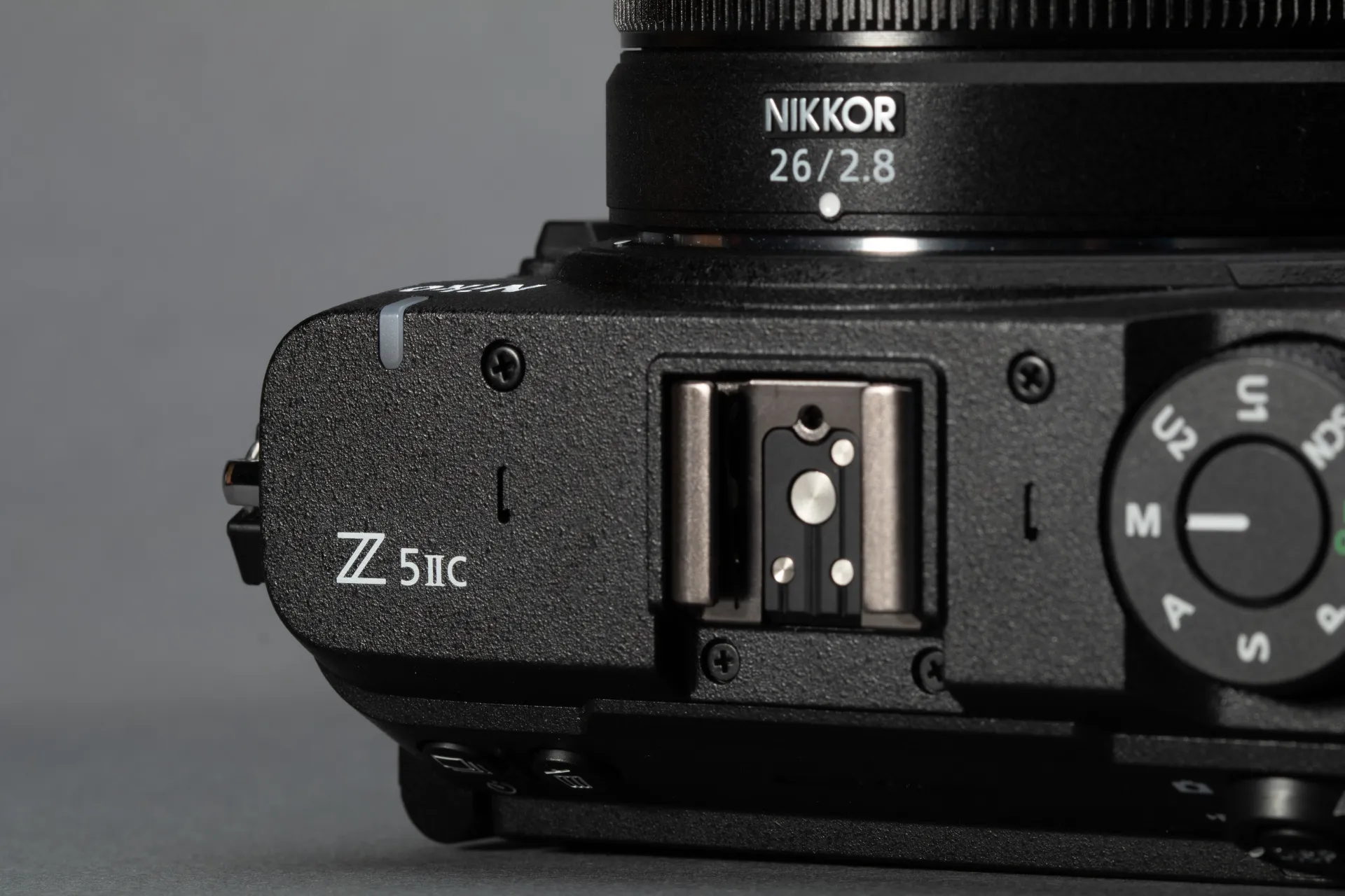 A view of a black Z5IIC's top plate showing the mode dial, hotshoe and name badge.