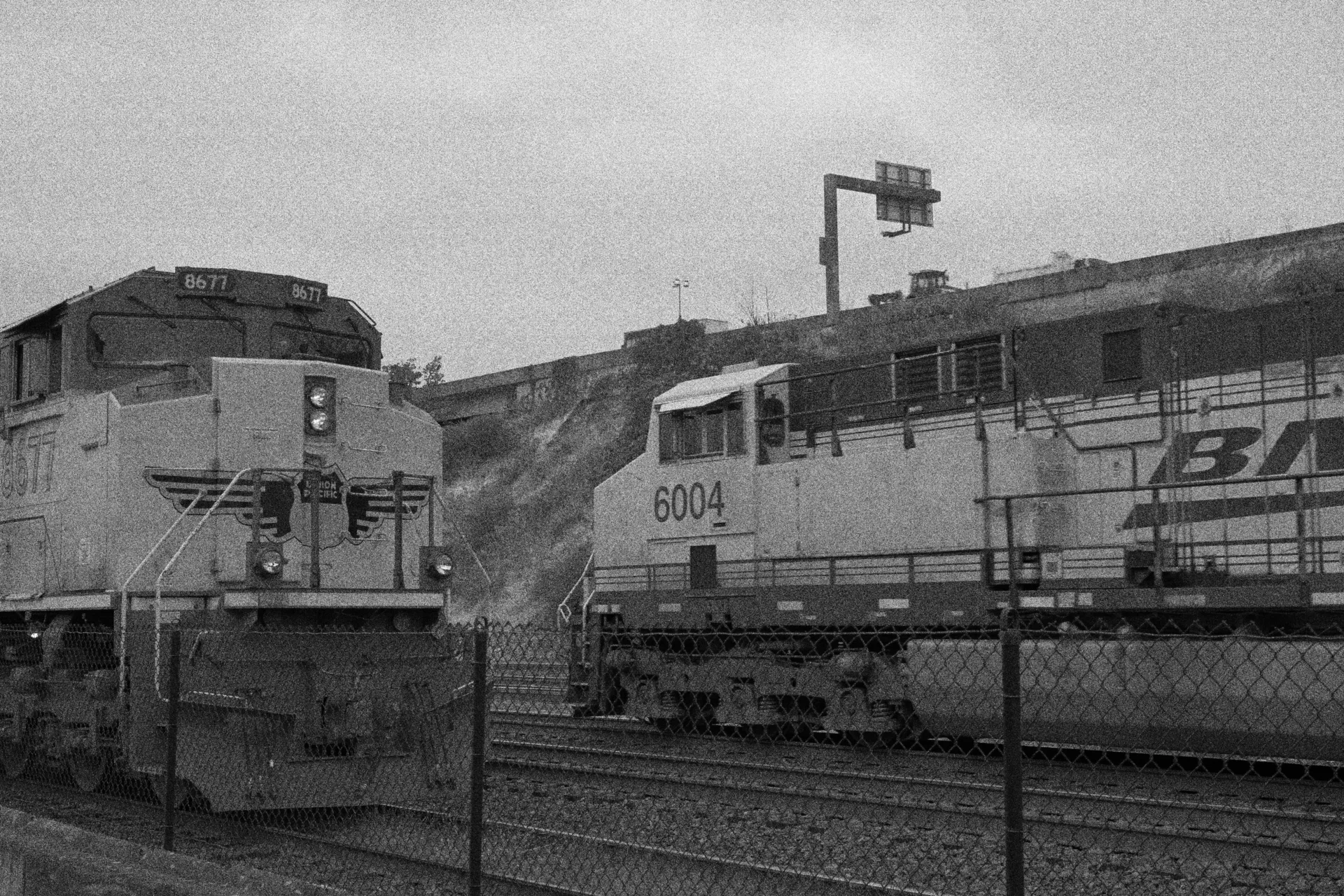 A grainy black and white photo of two trains on a track.