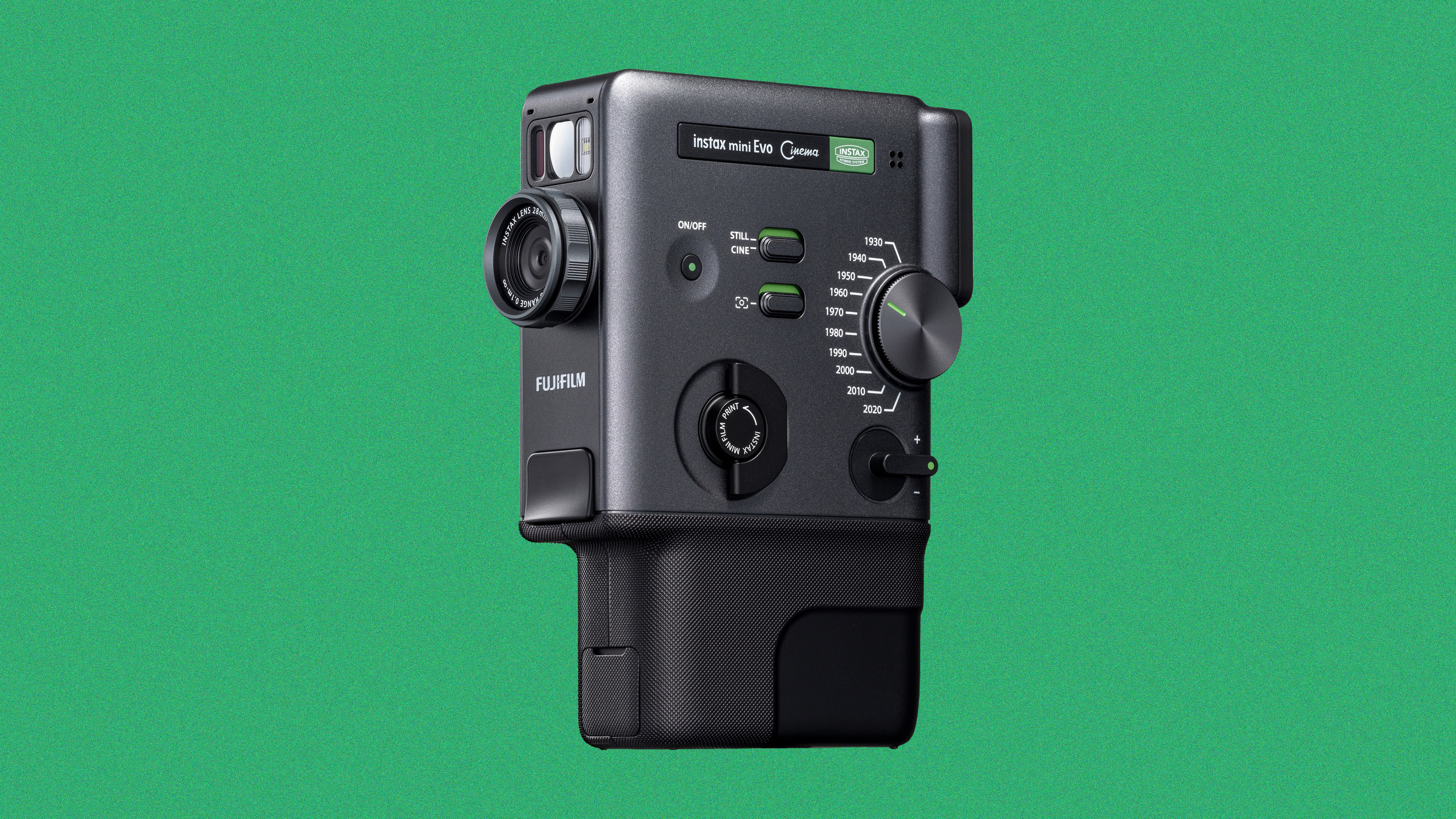 Fujifilm Instax mini Evo hybrid instant camera in charcoal gray, positioned against a green background.