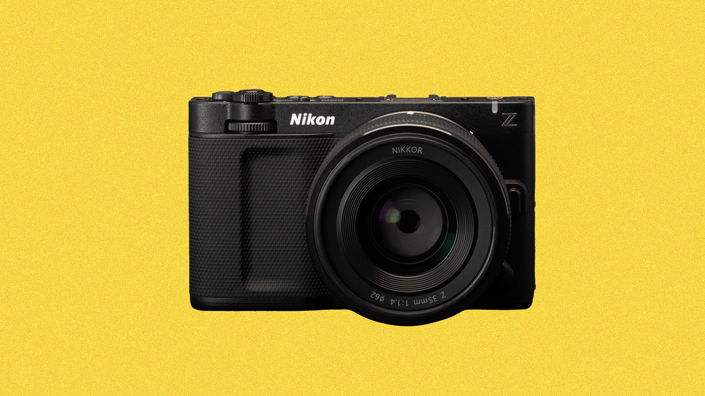 Black Nikon Z mirrorless camera with a 35mm lens attached, positioned against a solid yellow background.